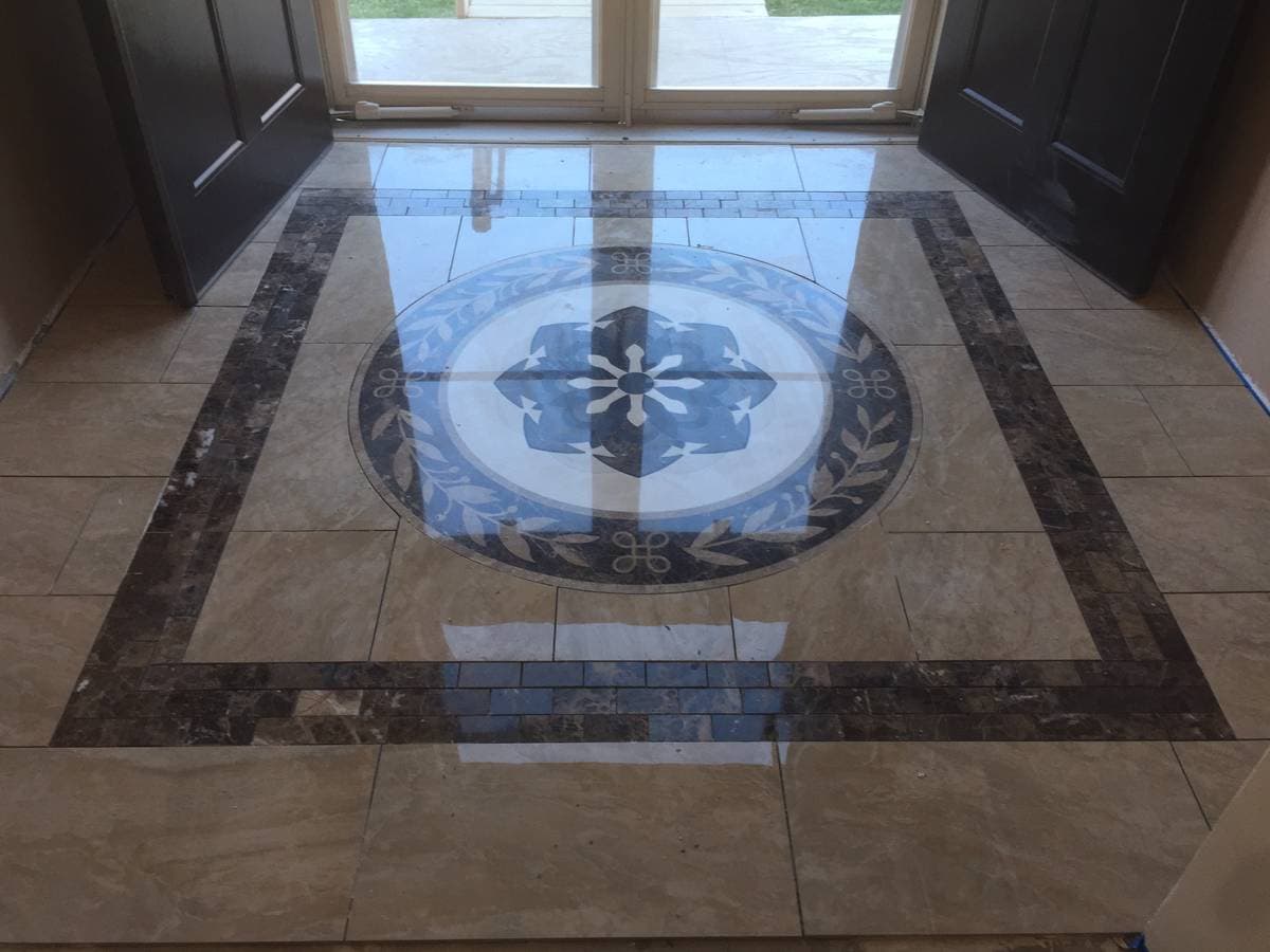 picture of a newly remodeled commercial tile floor with custom tile with tile logo 